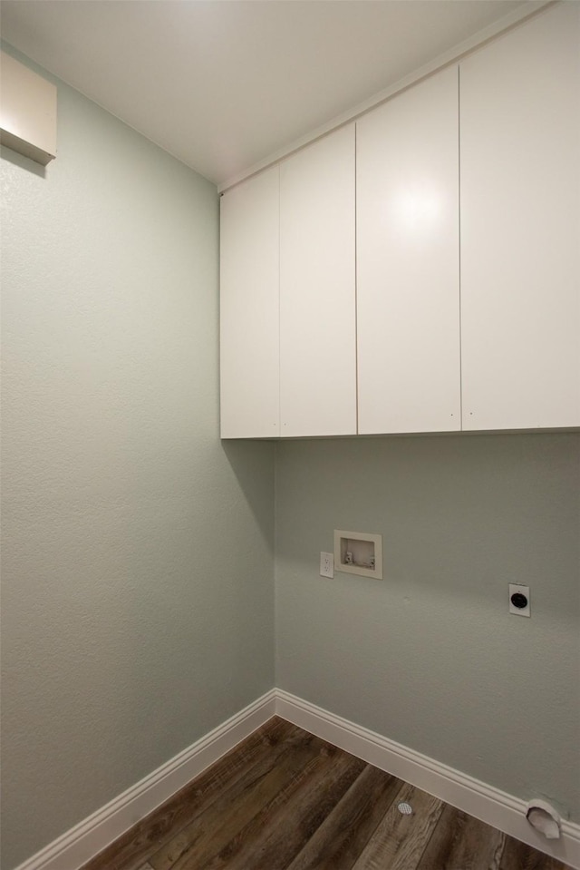 laundry area with hookup for a washing machine, electric dryer hookup, cabinet space, baseboards, and dark wood-style floors