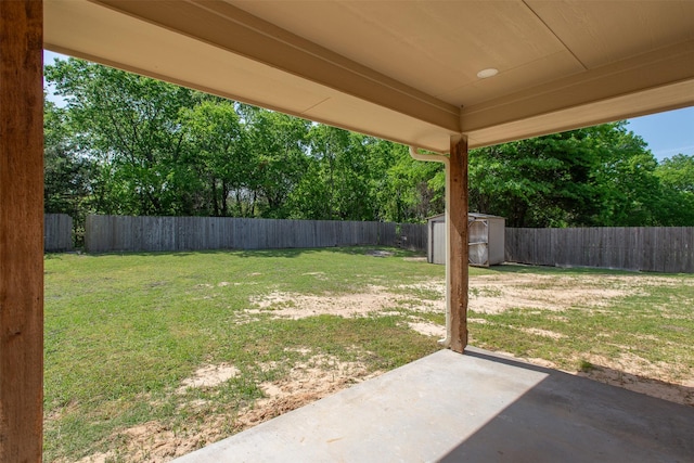 view of yard with a storage unit, an outbuilding, a fenced backyard, and a patio