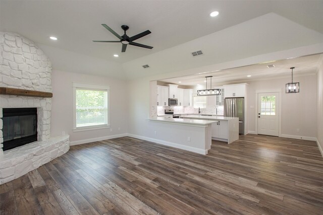 unfurnished living room featuring a ceiling fan, a fireplace, baseboards, dark wood-type flooring, and visible vents