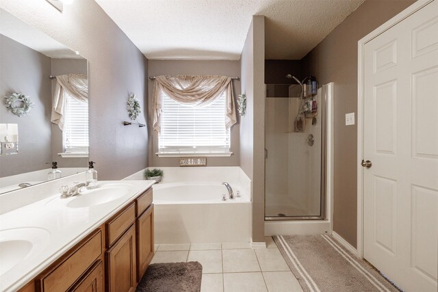 bathroom featuring a sink, tile patterned floors, a stall shower, double vanity, and a garden tub