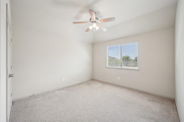 spare room with lofted ceiling, a ceiling fan, baseboards, and light colored carpet