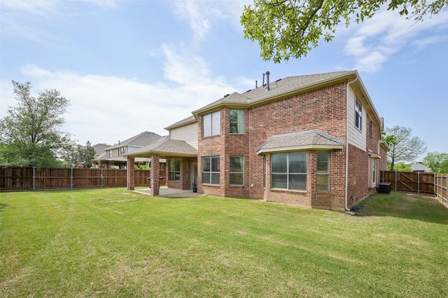 back of house featuring a lawn, a patio area, a fenced backyard, and brick siding