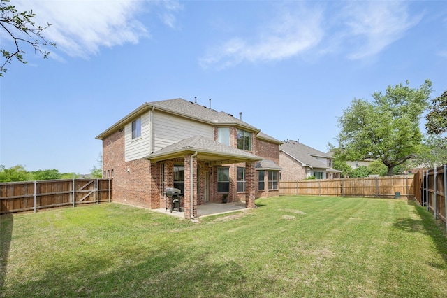 rear view of property with a fenced backyard, brick siding, a patio, and a lawn