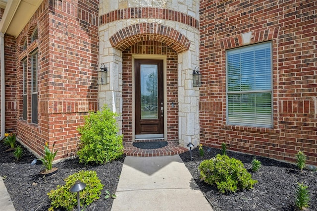view of exterior entry featuring brick siding