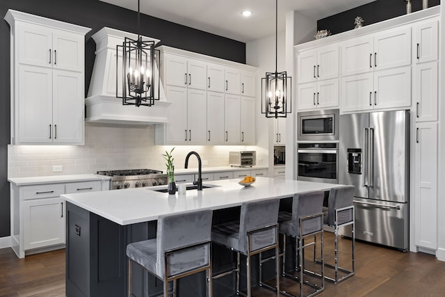 kitchen featuring an inviting chandelier, light countertops, a sink, appliances with stainless steel finishes, and dark wood-style flooring