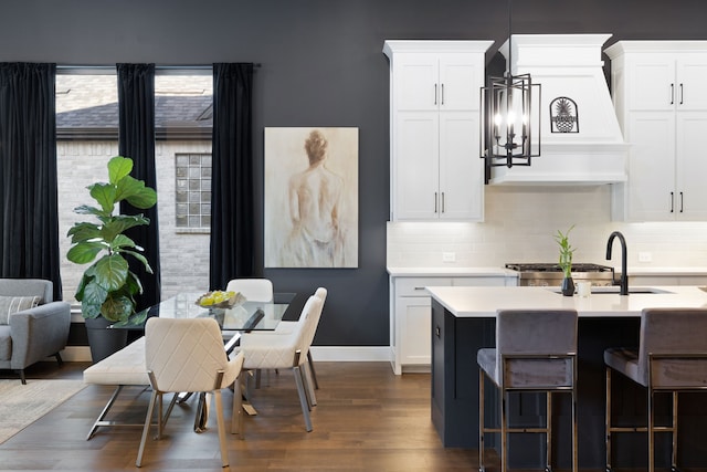 kitchen featuring decorative backsplash, a sink, dark wood-type flooring, and light countertops