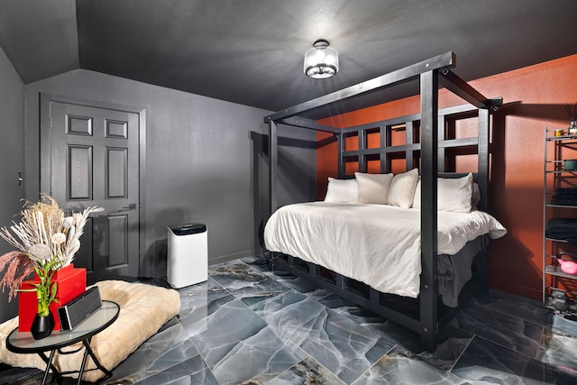 bedroom featuring vaulted ceiling and marble finish floor