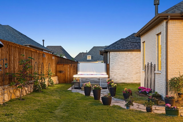 view of yard featuring a fenced backyard, a hot tub, and a patio