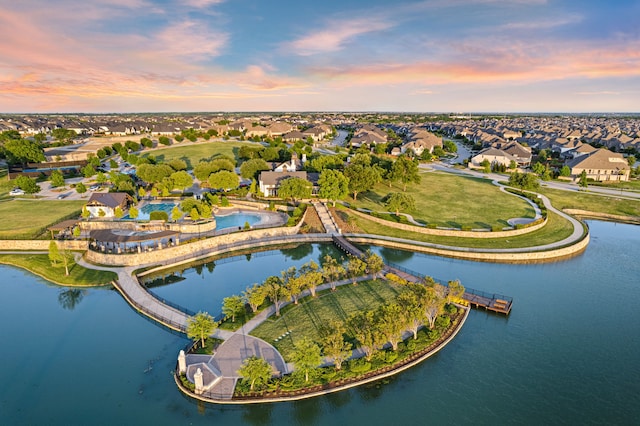 aerial view at dusk with a residential view and a water view