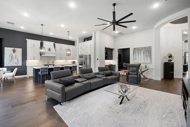 living room featuring recessed lighting, baseboards, a ceiling fan, and dark wood-style floors