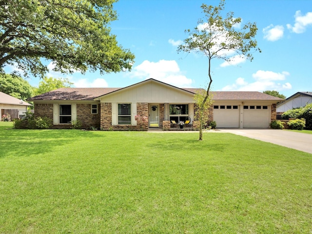 single story home featuring a front yard, covered porch, brick siding, concrete driveway, and an attached garage