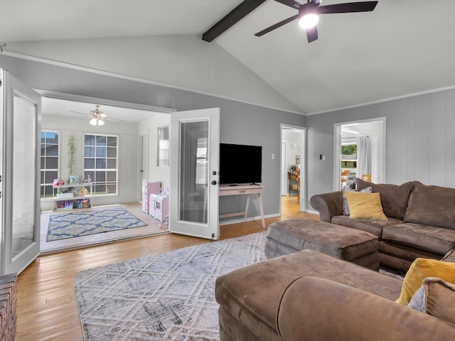living area featuring wood finished floors, a ceiling fan, and vaulted ceiling with beams