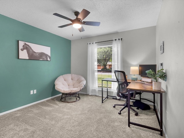 carpeted home office featuring a textured ceiling, a ceiling fan, and baseboards