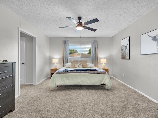 bedroom with ceiling fan, a textured ceiling, and light colored carpet
