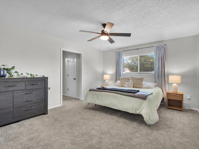 bedroom featuring a textured ceiling, ceiling fan, light colored carpet, and baseboards