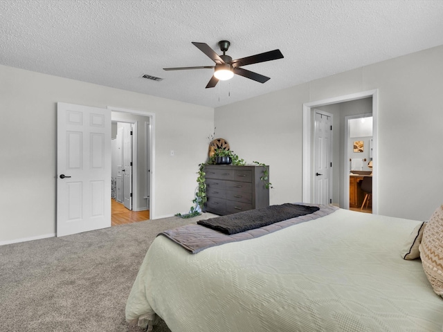 bedroom featuring ceiling fan, visible vents, baseboards, a textured ceiling, and carpet floors