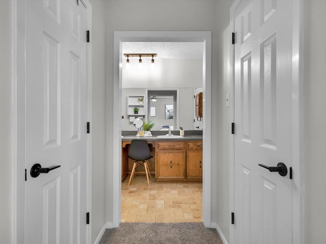 hall with baseboards and brick floor