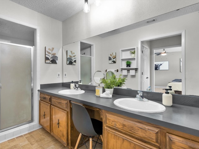 ensuite bathroom with visible vents, ensuite bath, a textured ceiling, and a sink