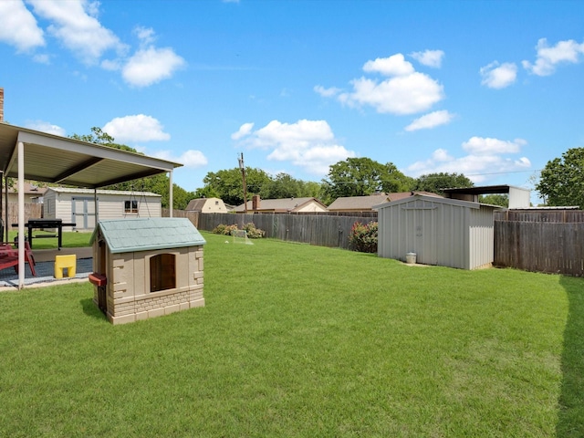 view of yard with a storage shed, a fenced backyard, and an outbuilding