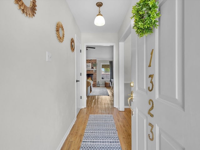 hall featuring baseboards and light wood-style floors
