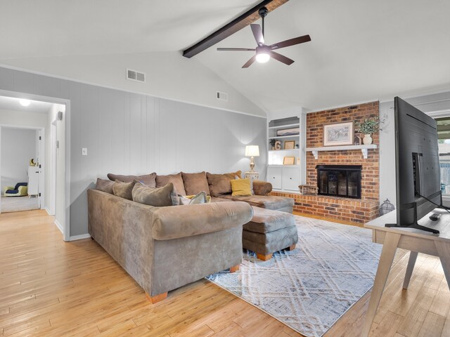 living room featuring visible vents, a ceiling fan, light wood-style flooring, and a brick fireplace