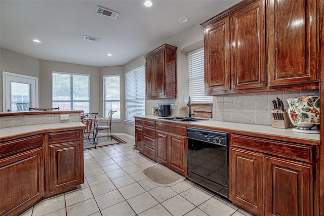 kitchen with black dishwasher, light countertops, visible vents, and a sink