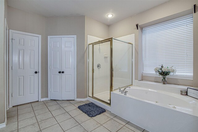 bathroom with a bath, tile patterned flooring, and a stall shower