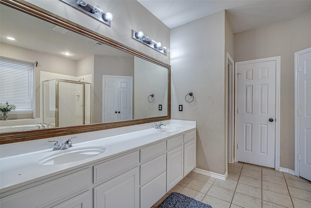 bathroom with tile patterned flooring, a sink, double vanity, and a stall shower