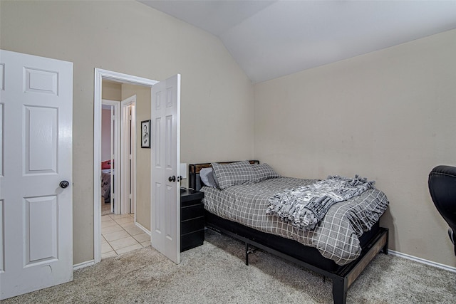 carpeted bedroom featuring vaulted ceiling and baseboards