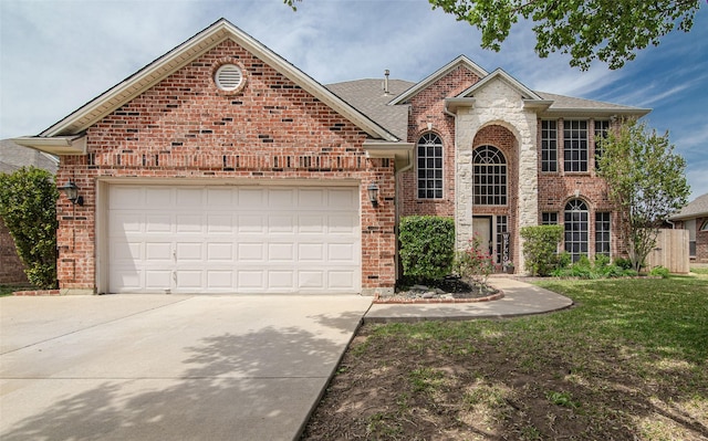 traditional home featuring a front lawn, roof with shingles, concrete driveway, brick siding, and a garage