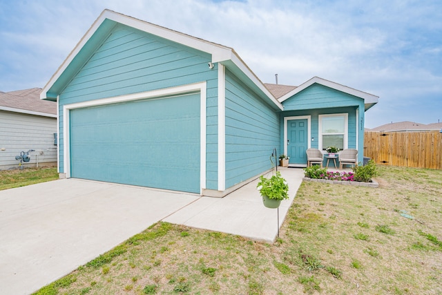 single story home featuring an attached garage, a front yard, and fence