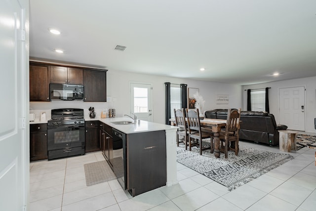 kitchen featuring light countertops, visible vents, a sink, black appliances, and a peninsula
