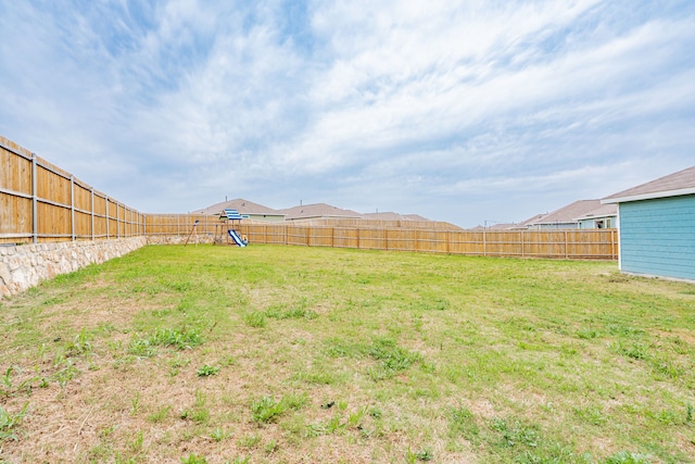 view of yard with a fenced backyard and a playground
