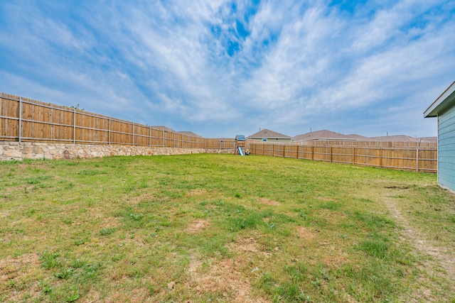 view of yard with a fenced backyard and a playground