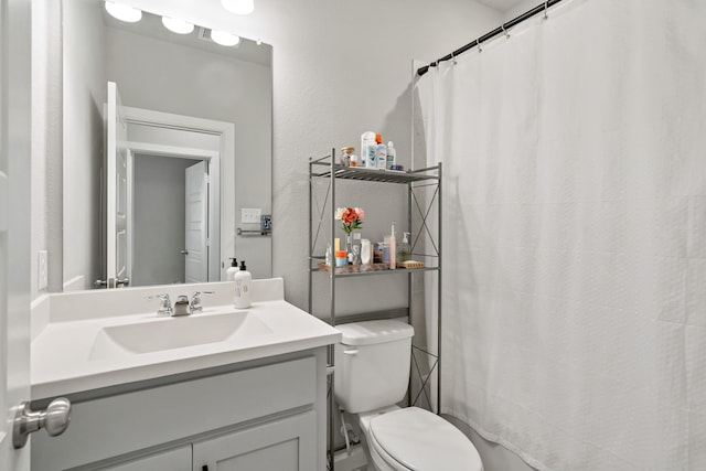 full bath featuring a shower with curtain, vanity, and toilet
