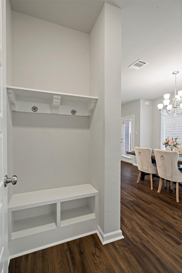 mudroom featuring an inviting chandelier, dark wood-style flooring, visible vents, and baseboards