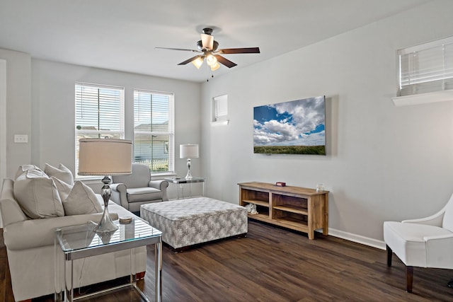 living area featuring baseboards, ceiling fan, and dark wood-style flooring