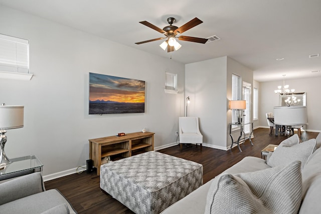 living room featuring ceiling fan with notable chandelier, baseboards, wood finished floors, and visible vents