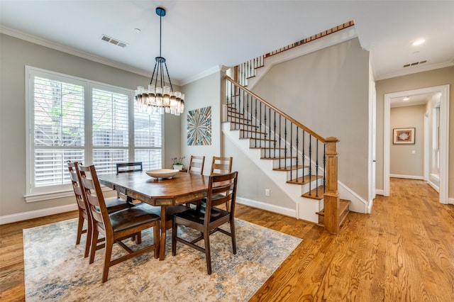 dining room with visible vents, an inviting chandelier, stairs, and crown molding