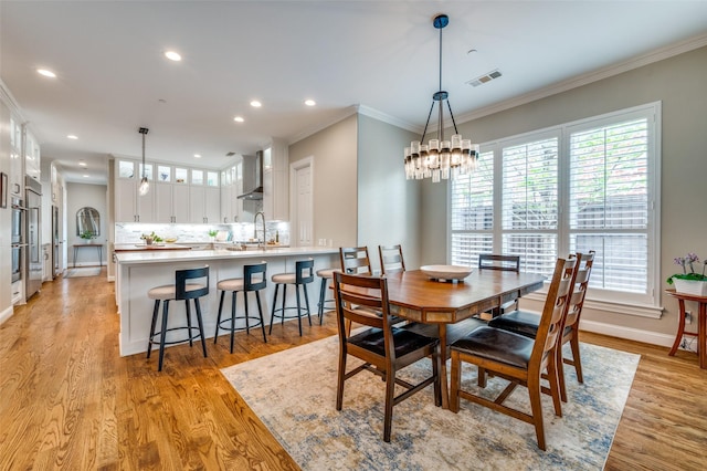 dining area featuring light wood-type flooring, plenty of natural light, visible vents, and a notable chandelier