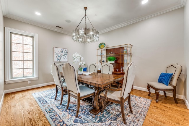 dining room with visible vents, light wood-style floors, crown molding, baseboards, and a chandelier