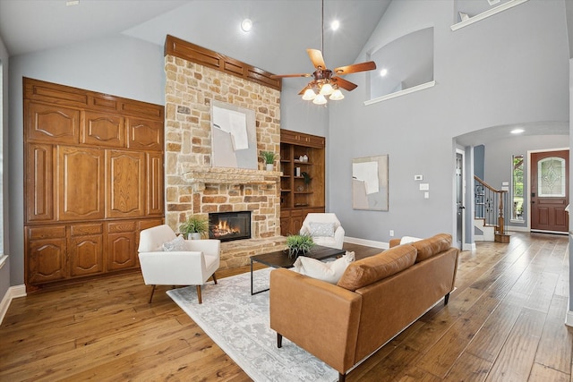 3417 Bear Creek Dr, Hurst, TX 76054 - living room featuring high vaulted ceiling, a fireplace, light wood finished floors, stairway, and a ceiling fan