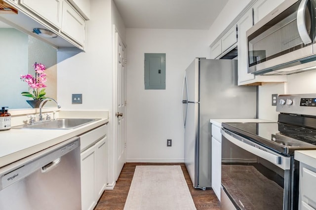 kitchen featuring a sink, electric panel, stainless steel appliances, light countertops, and dark wood-style floors