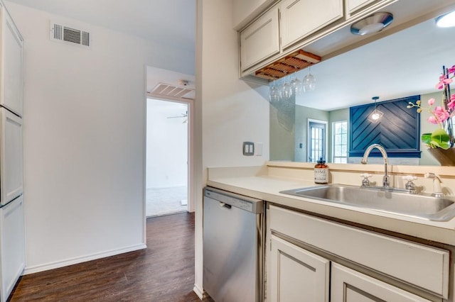 kitchen featuring dark wood finished floors, light countertops, dishwasher, visible vents, and a sink