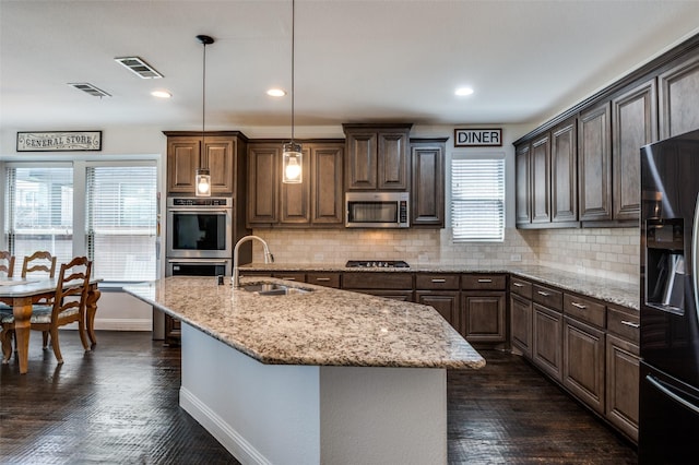 kitchen with visible vents, baseboards, stainless steel appliances, and a sink
