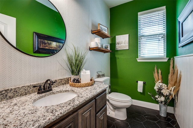 bathroom with baseboards, vanity, tile patterned flooring, and toilet