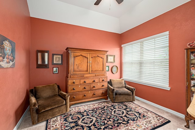 sitting room featuring light colored carpet, baseboards, and a ceiling fan