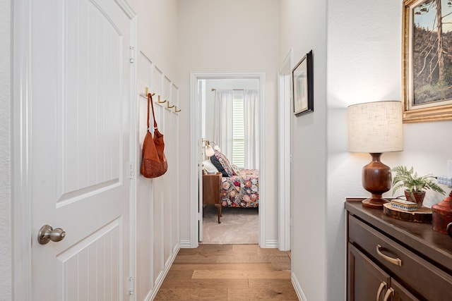 hall featuring baseboards and light wood-style floors