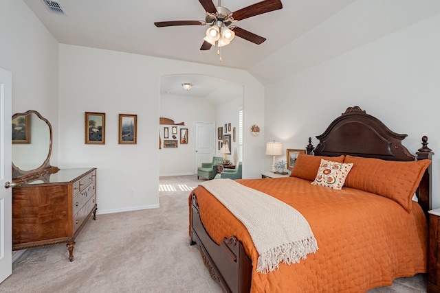 bedroom with vaulted ceiling, visible vents, arched walkways, baseboards, and light colored carpet