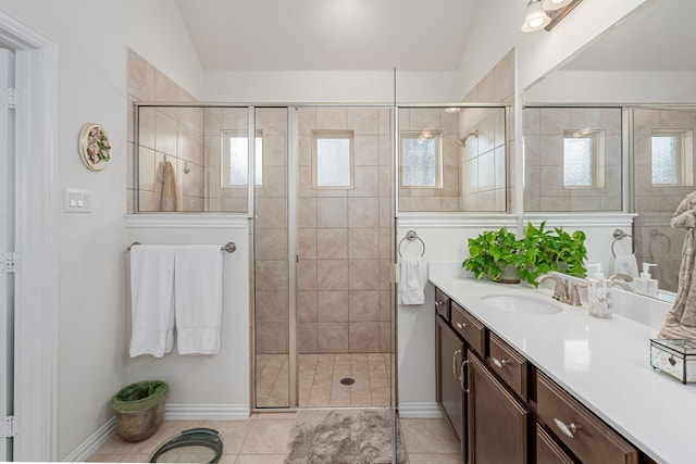 full bath featuring vaulted ceiling, vanity, tile patterned flooring, and a shower stall